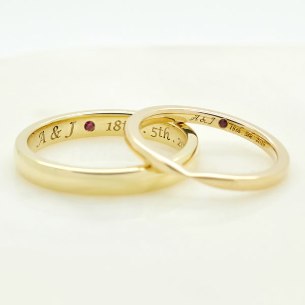 yellow gold matching ladies and mens wedding rings with date inscription engraving and ruby